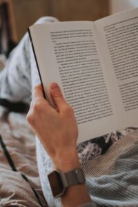 A relaxed scene of a person holding an open book, featuring cozy attire and an inviting atmosphere.
